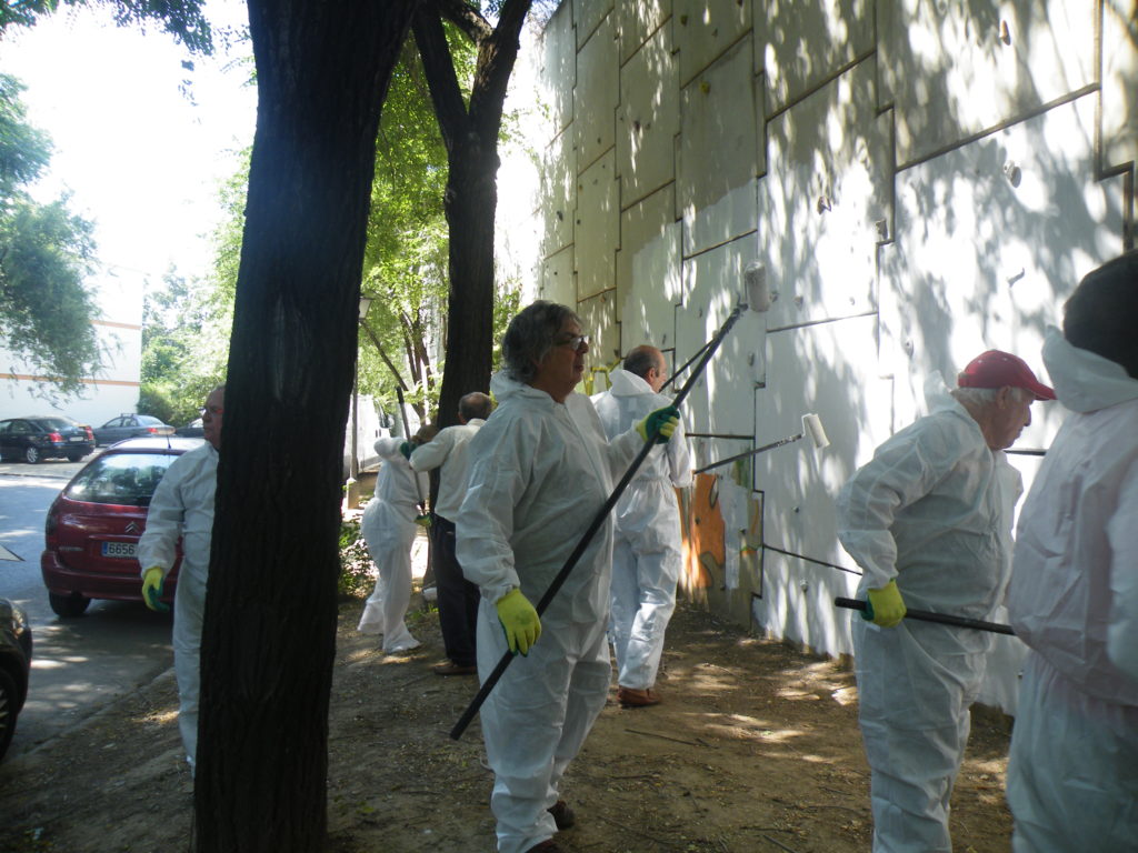 Vecinos participando en la retirada de pinturas del muro de defensa